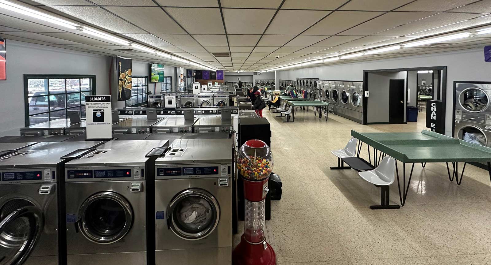 interior view of stadium discount laundry - large laundromat with many washing machines and dryers